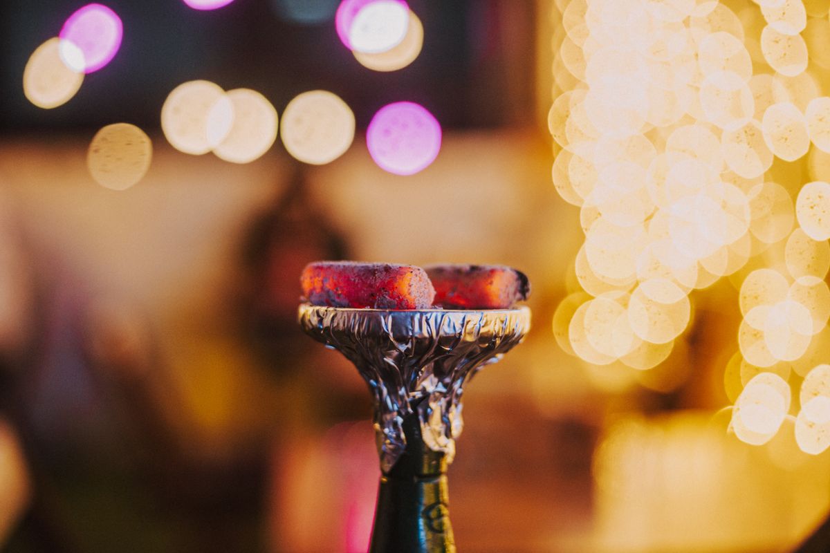 Glowing shisha coals with warm lounge bokeh